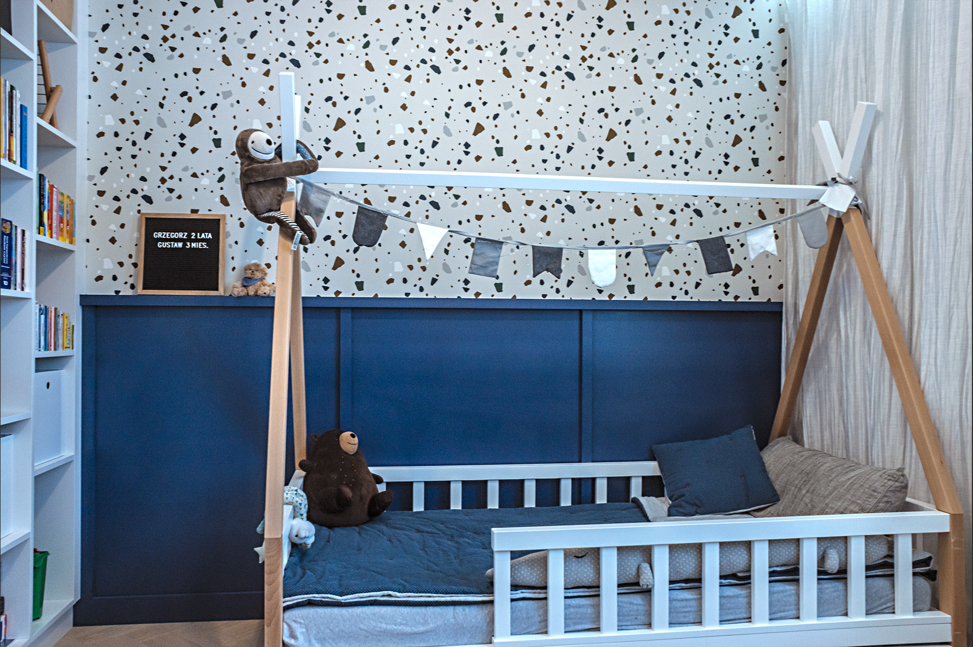 Ponad boazerią pokoju dziecięcego – tapeta z wzorem terazzo o odpowiedniej palecie barwnej.