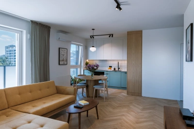 Projekt minimalistycznego wnętrza na Mokotowie w stylistyce nawiązującej do lat 60tych &ndash; sofa nie krępuje dostępu do obu drzwi balkonowych