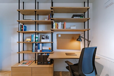 Projekt minimalistycznego wnętrza na Mokotowie w stylistyce nawiązującej do lat 60tych &ndash; biurko zintegrowane z regałem bibliotecznym w gabinecie
