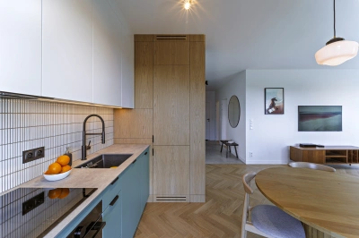 Projekt minimalistycznego wnętrza na Mokotowie w stylistyce nawiązującej do lat 60tych &ndash; wielofunkcyjna szafa kuchenna pokryta naturalnym dębowym fornirem