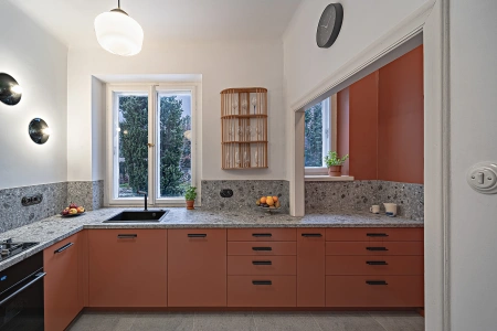 Projekt kuchni w modernistycznej willi pod Warszawą - dzięki rezygnacji z typowych szafek wiszących wyeksponowano duże okna z widokiem na ogród.