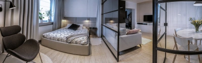 Projekt nowego układu funcjonalnego apartamentu na Ursynowie – dobrze oświetlony fotel w sypialni pozwala na komfortową lekturę