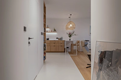 Projekt sprzyjającego relaksowi apartamentu z funkcją galeryjną – łączenie dwóch rodzajów podłóg: epoksydowej i drewnianej na styku korytarza z salonem