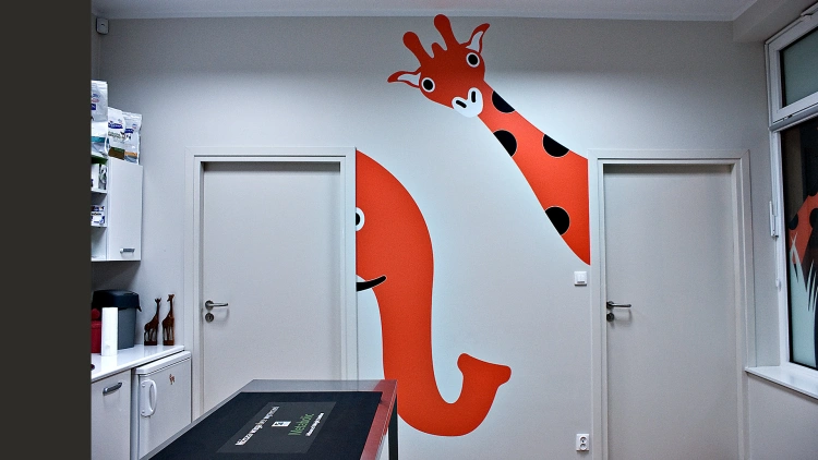 Projekt wnętrz przychodni weterynaryjnej: nasz układ funkcjonalny zoptymalizował rozmieszczenie sprzętów i mebli. Przychodnię udekorowaliśmy wielkimi naklejkami rysunkowych zwierząt.